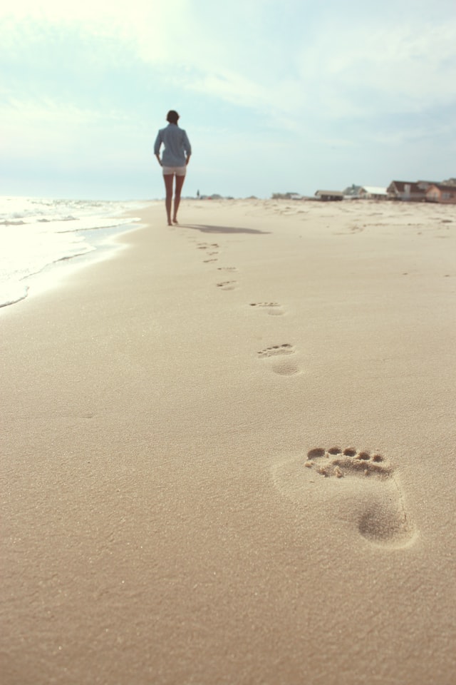 Woman's footsteps in sand.